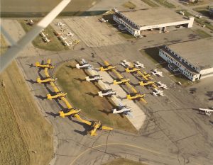 Aerial view of Springbrook Aerospace, multiple aircrafts parked outside of hangar at YQF Airport