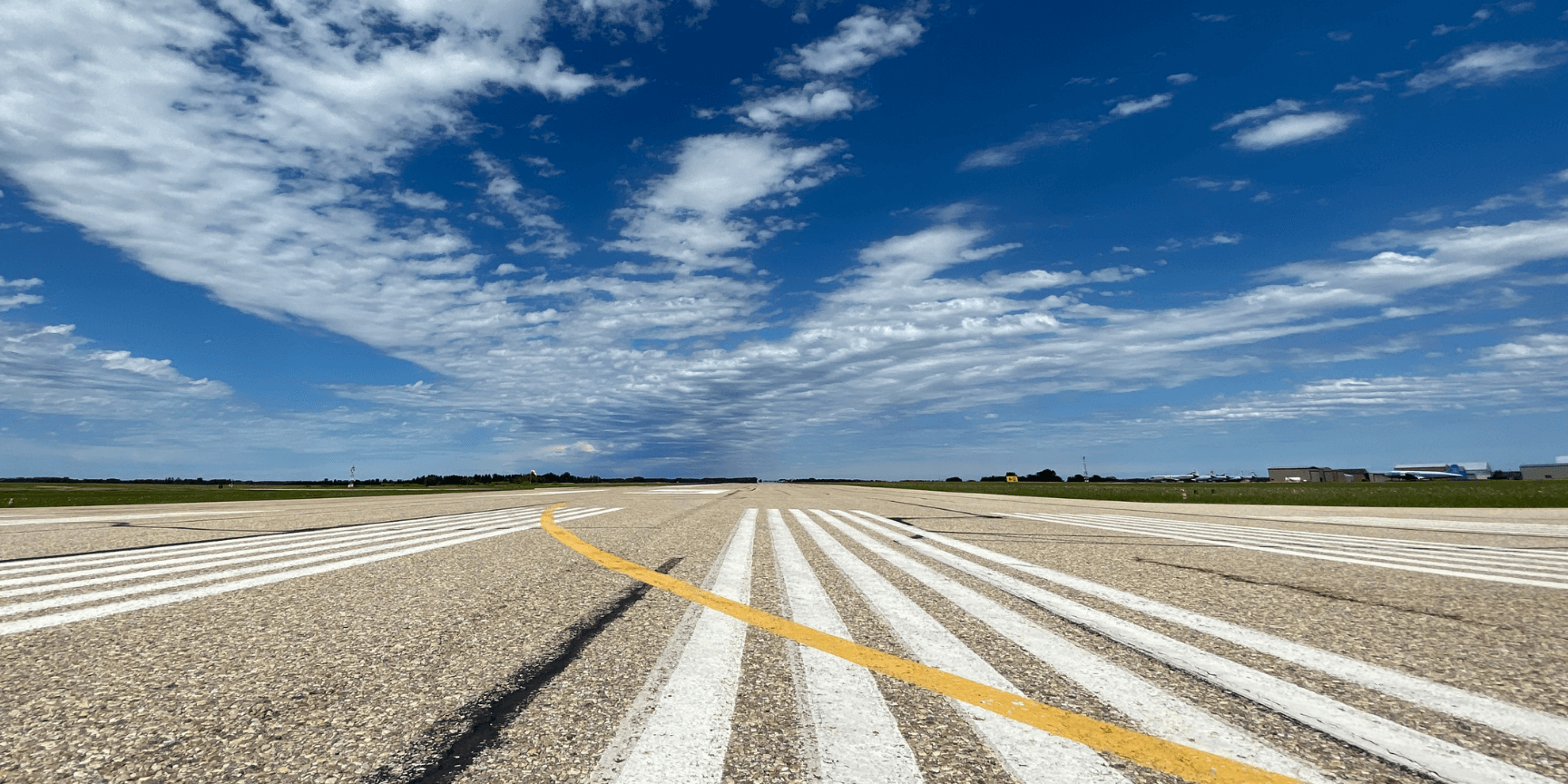 Clouds and blue sky above runway at Red Deer Regional Airport