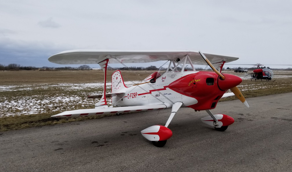 Red Deer Flying Club small red and white aircraft parked on airport runway