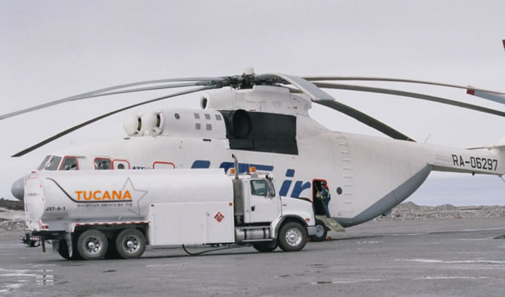 Tucana Aviation Service fuel truck delivering fuel to commercial helicopter YQF airport runway